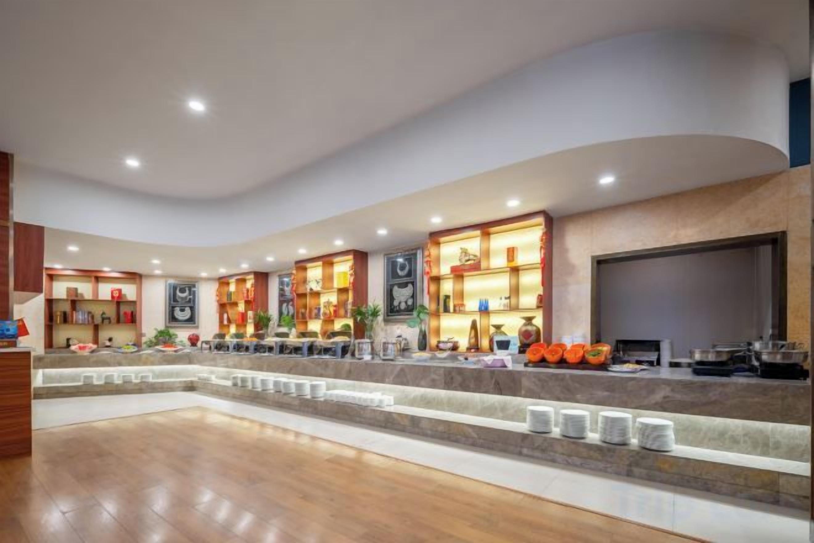 A hotel lobby with a curved ceiling, a reception desk, and a seating area.