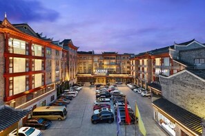 A hotel with a courtyard parking area, traditional architecture, and multiple floors. - Phoenix International Hotel (Fenghuang Ancient Town Branch) (Fenghuang County)