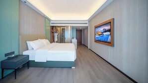 A modern hotel room with a bed, bedside table, and a painting on the wall. - Phoenix International Hotel (Fenghuang Ancient Town Branch) (Fenghuang County)