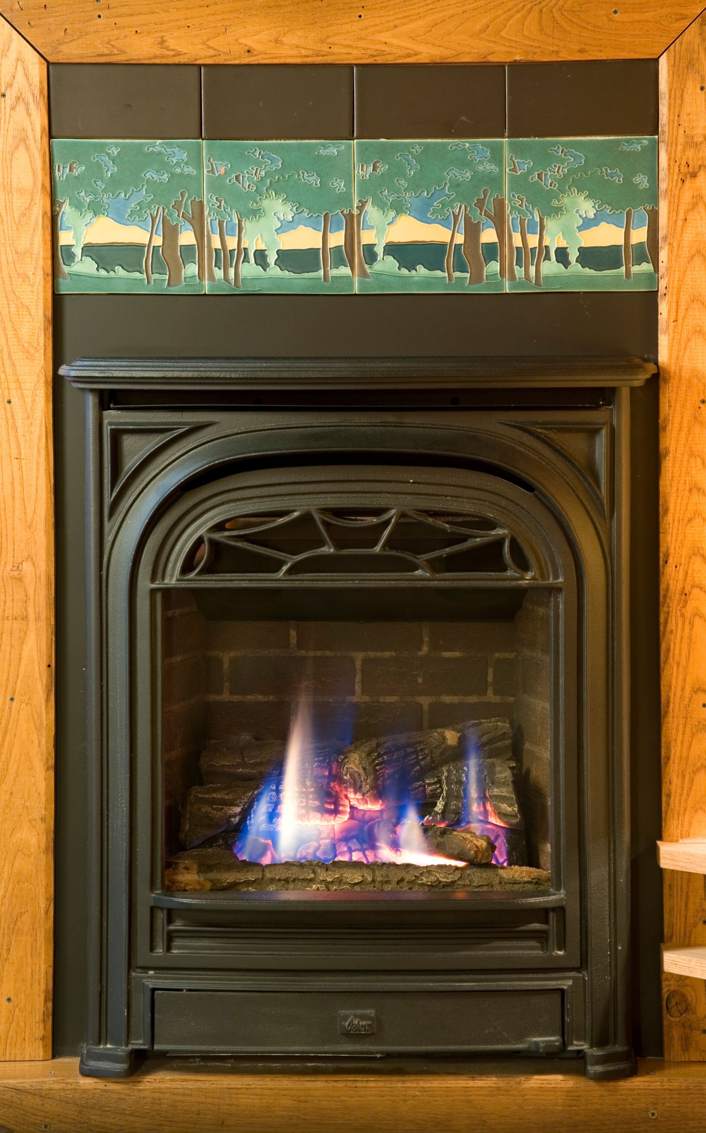 Una chimenea con repisa de azulejos y nombre de marca visible.