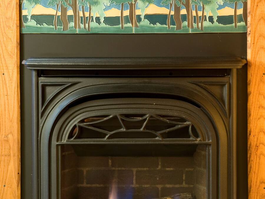 Una chimenea con repisa de azulejos y nombre de marca visible.