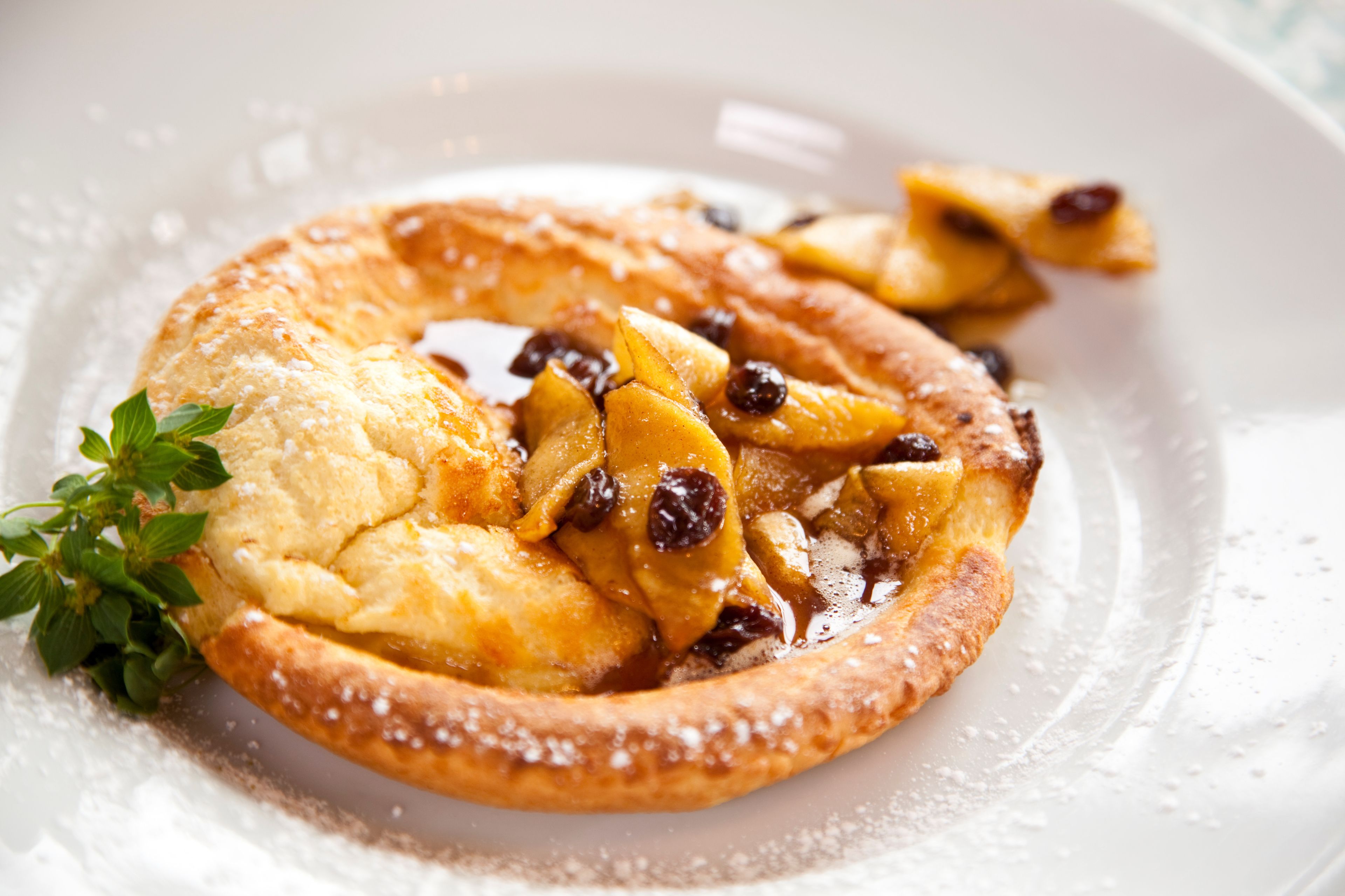 A dessert with a pastry base, fruit pieces, and a sprig of mint.
