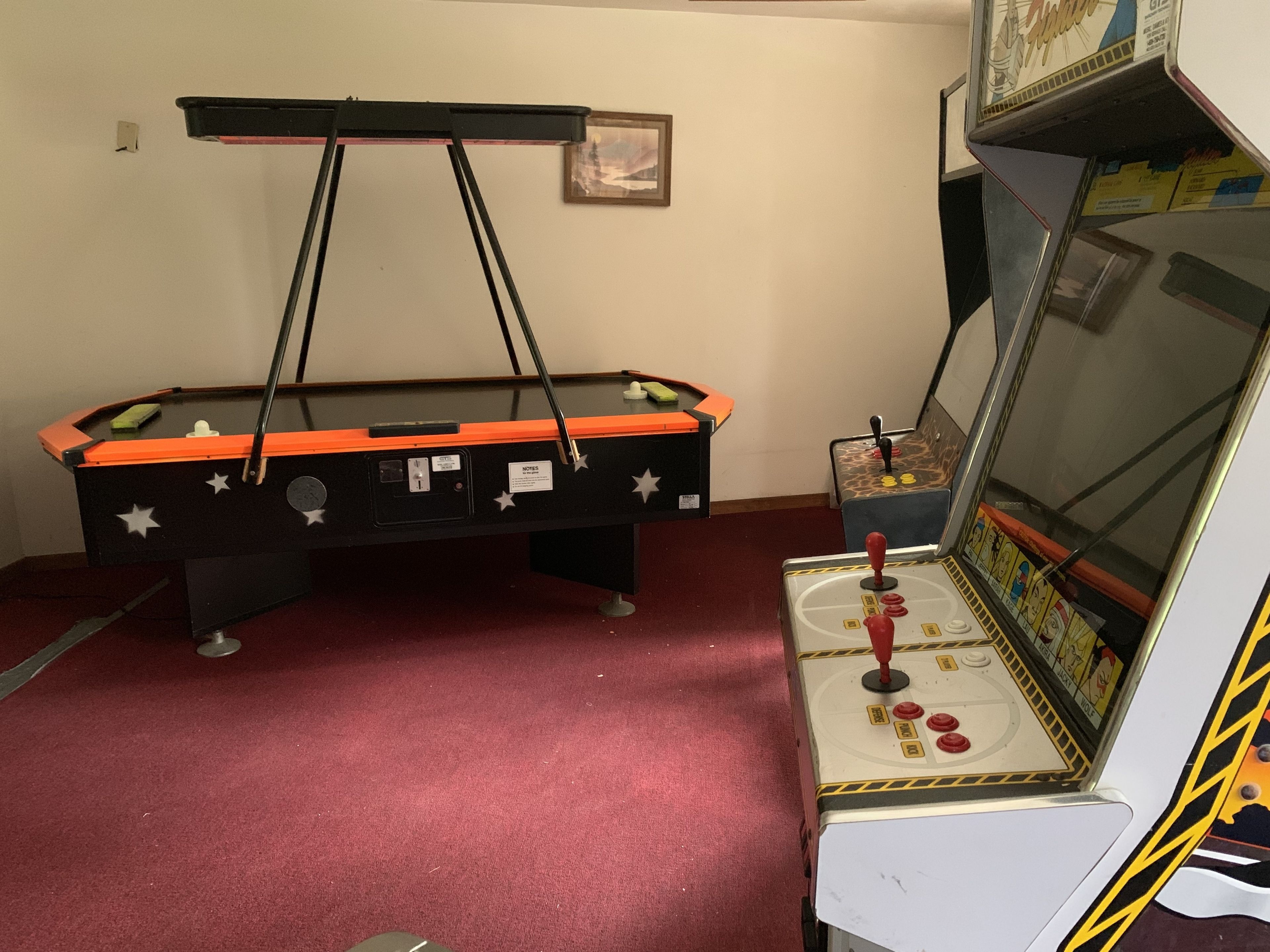 A pool table with a mirrored cabinet and a pinball machine.