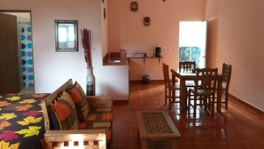 Una sala de estar acogedora con un sofá, una mesita y un comedor con sillas.