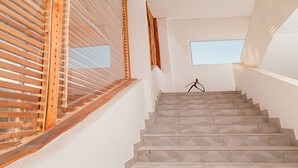 Eine Treppe mit Steinstufen führt zu einer Zwischenebene mit einem kleinen Fenster.
