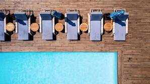 A rooftop pool area with six lounge chairs and a wooden deck. - Andaz West Hollywood (West Hollywood)