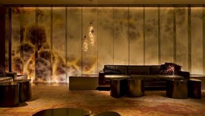A modern lounge area with a sofa, coffee tables, and a unique wall with a textured pattern. - Andaz West Hollywood (West Hollywood)