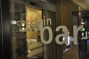 A window with the text 'check in bar' and a star symbol, indicating a check-in area or bar within a hotel.