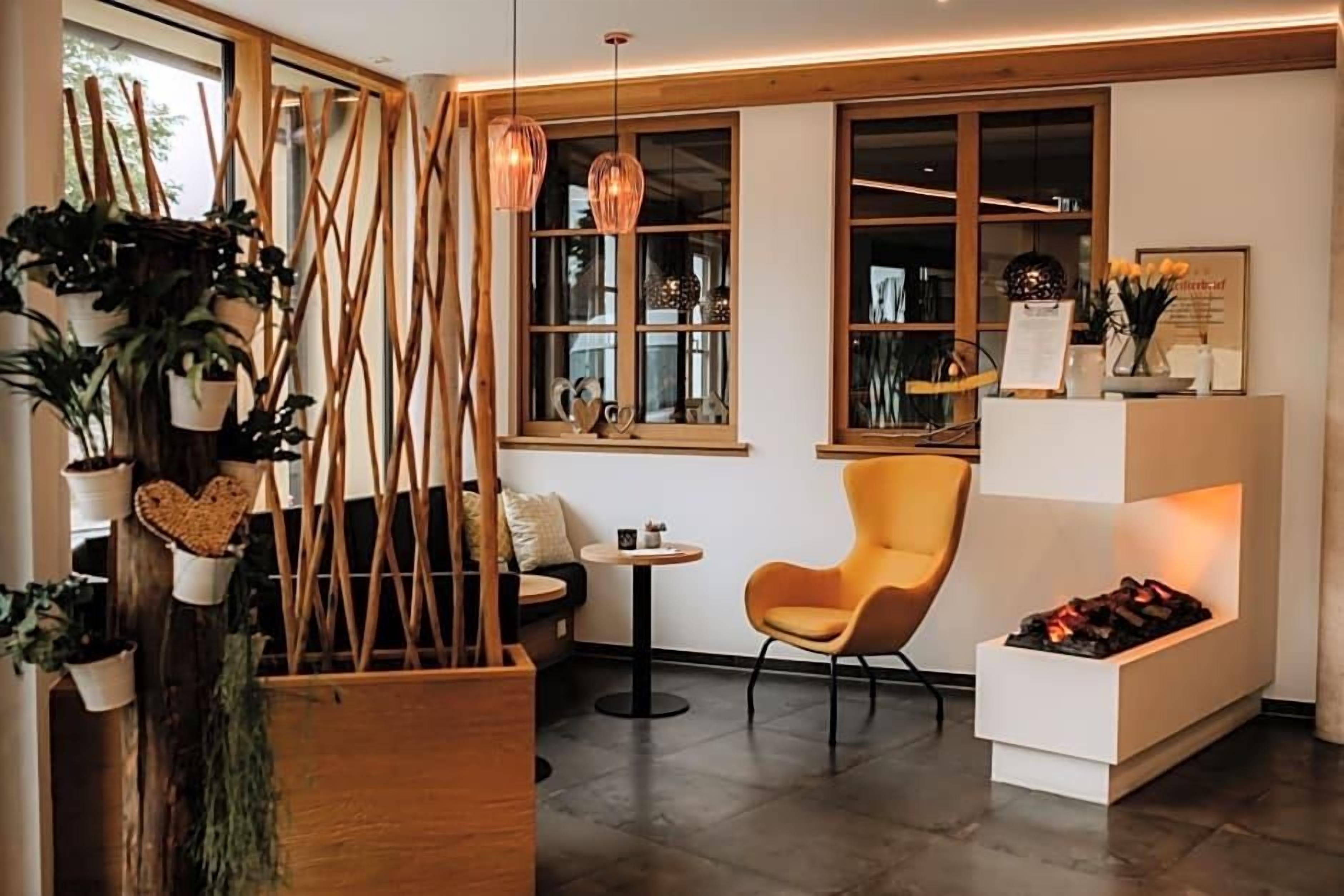 Un intérieur moderne avec une cloison en bois, une table ronde, une chaise jaune et une cheminée.
