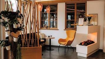 Un intérieur moderne avec une cloison en bois, une table ronde, une chaise jaune et une cheminée.