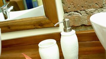 A wooden surface with a white towel, a decorative flower, and two white candle holders.