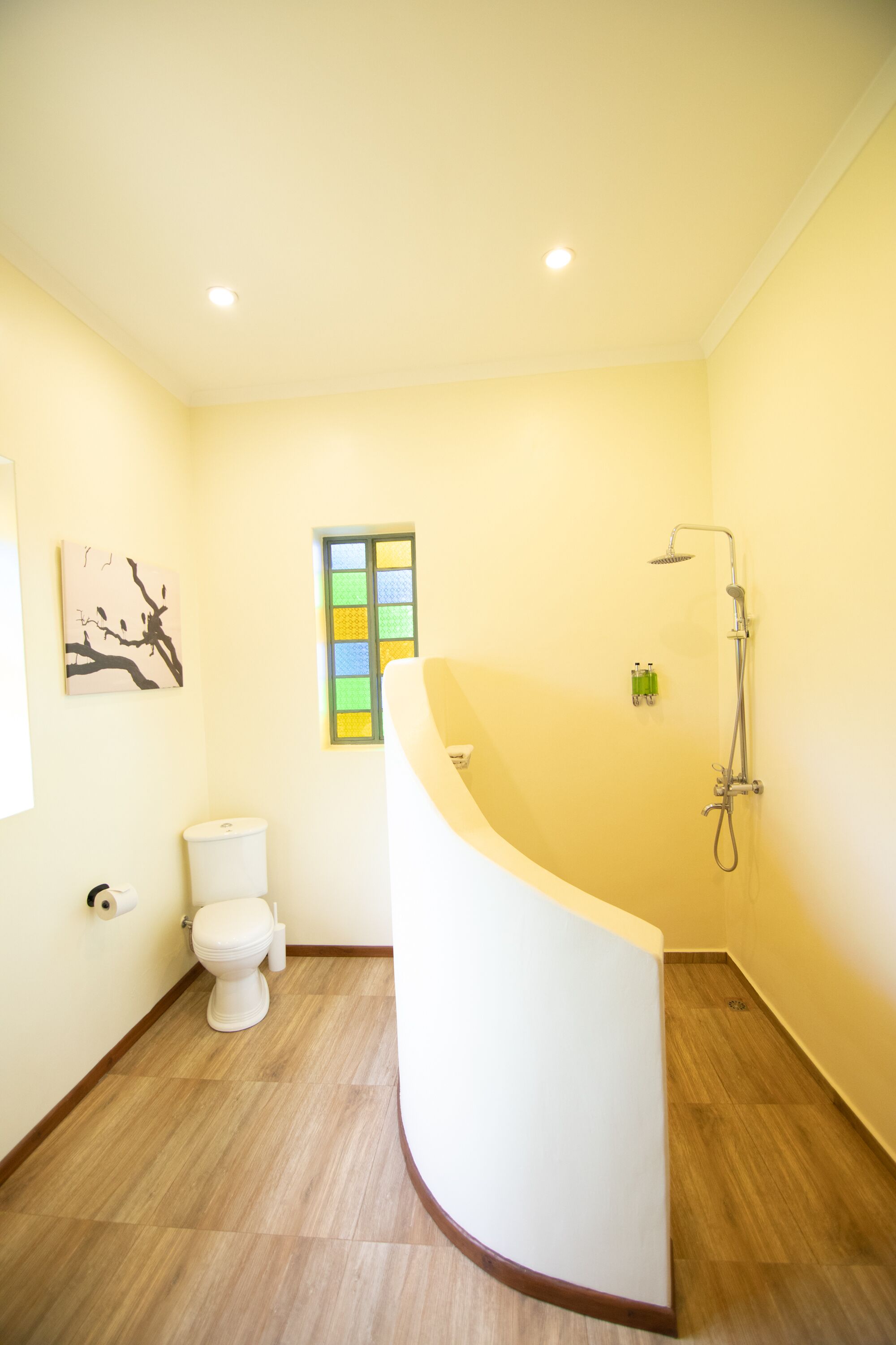 A bathroom with a white bathtub, a toilet, and a shower.