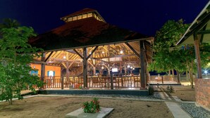 A covered outdoor area with a wooden structure, seating, and a small garden. - Charlestina Beach Resort (Ampenyi)
