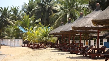 Privat strand, hvit sand, solsenger og parasoller