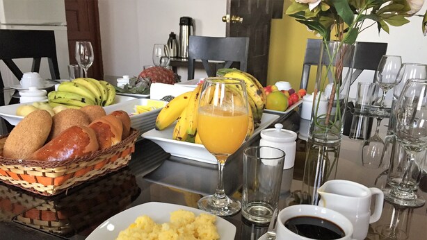 A breakfast buffet with bread, fruits, scrambled eggs, and coffee. - Pension Sanbleña B&B (Cusco)
