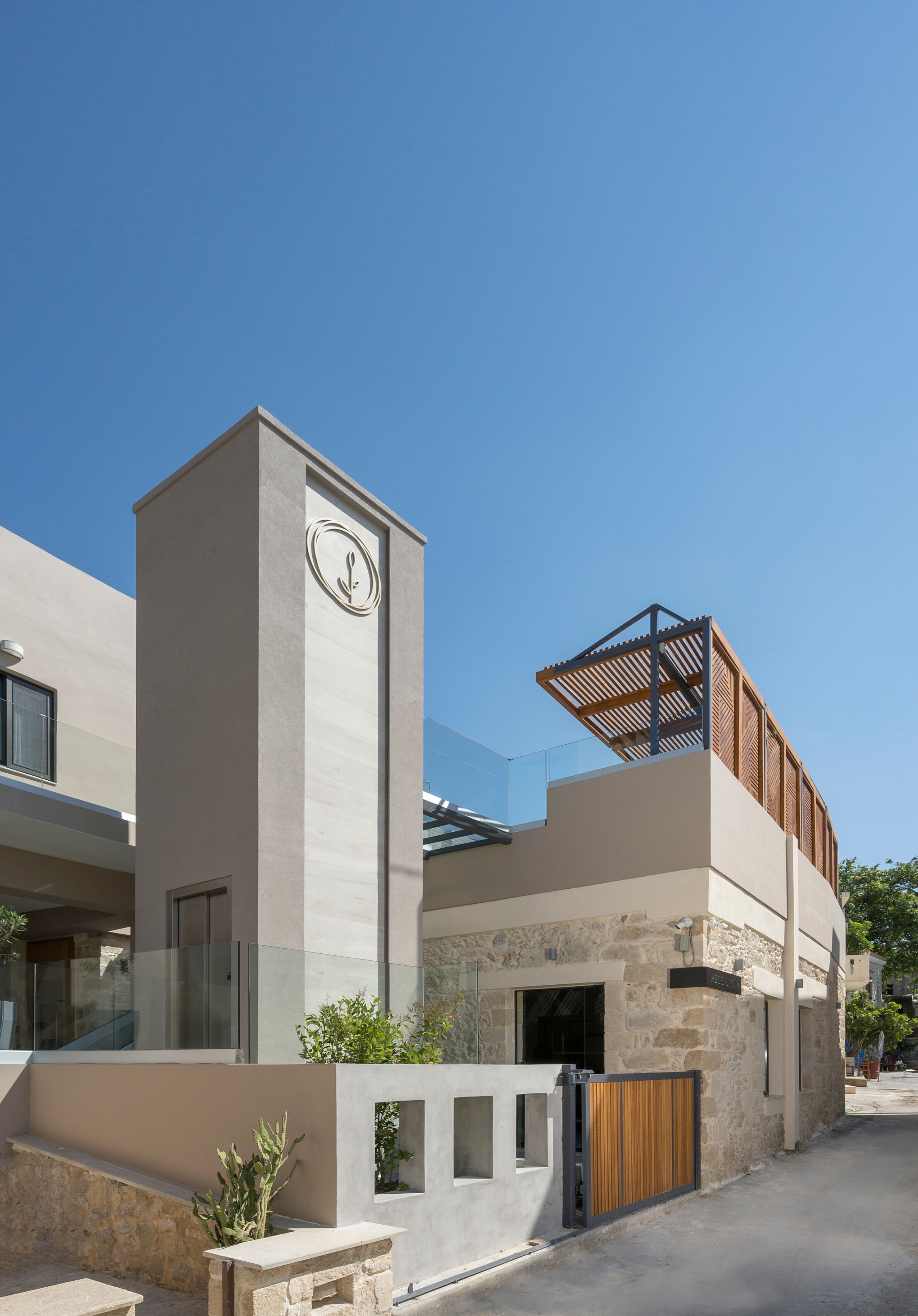 Un bâtiment moderne doté d’un imposant clocher, d’un espace extérieur abrité avec des sièges et d’une façade en pierre.
