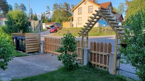 A rural house with a wooden gate and a red car parked in the driveway. - Stop at The Cross (Dalsjöfors)