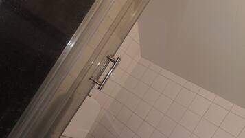 Ein Badezimmer mit Toilette, Waschbecken und Duschbereich.