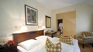 A hotel room with two beds, a nightstand, a lamp, a mirror, a chair, and a coat rack. - Wegermann S Bio Landhaus Im Wodantal (Hattingen)