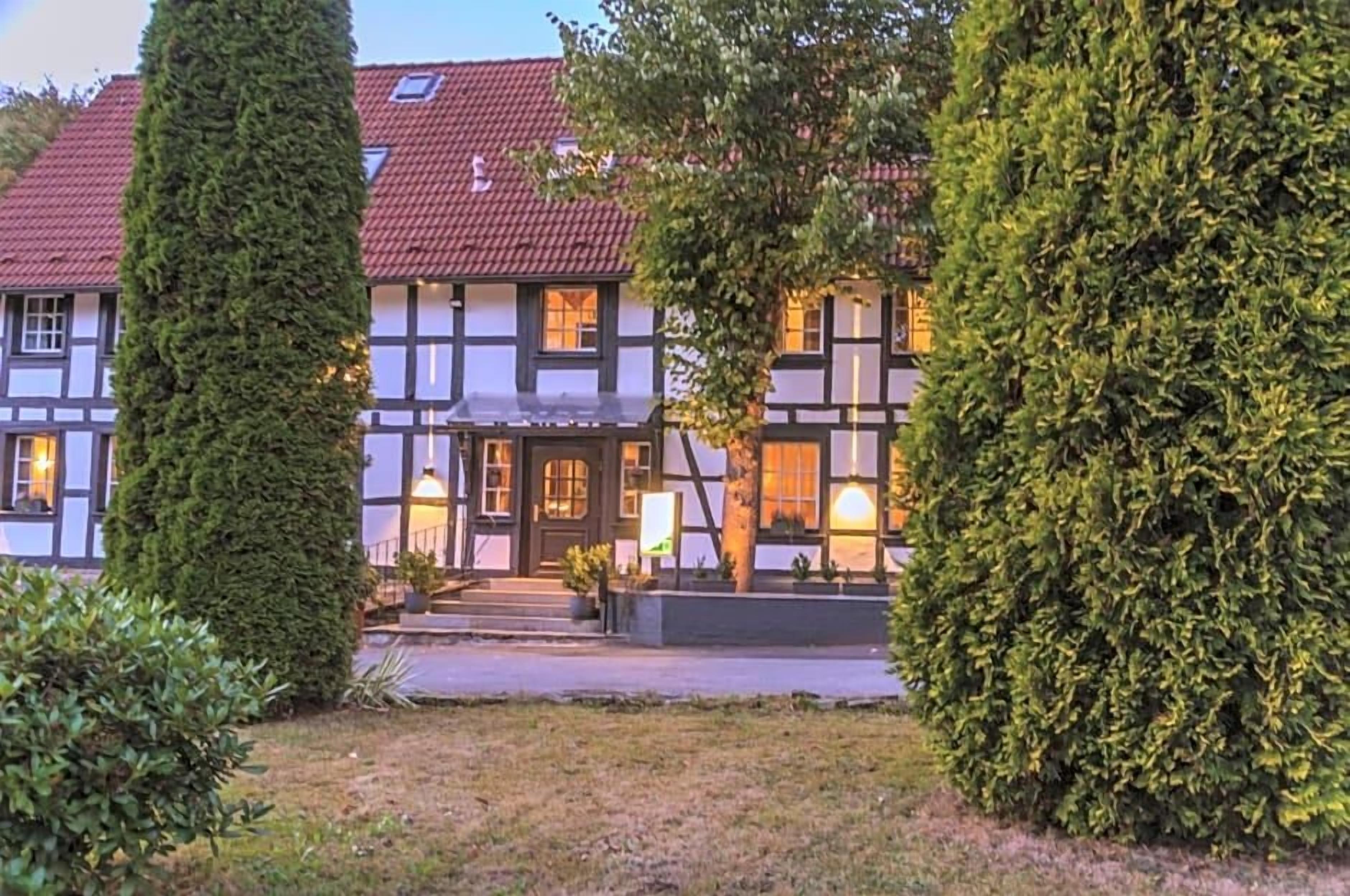 Een karakteristiek vakwerkhuis met een verzorgde tuin en een helder pad naar de ingang.