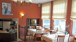A dining area with wooden flooring, a chandelier, and large windows with curtains. - Wegermann S Bio Landhaus Im Wodantal (Hattingen)