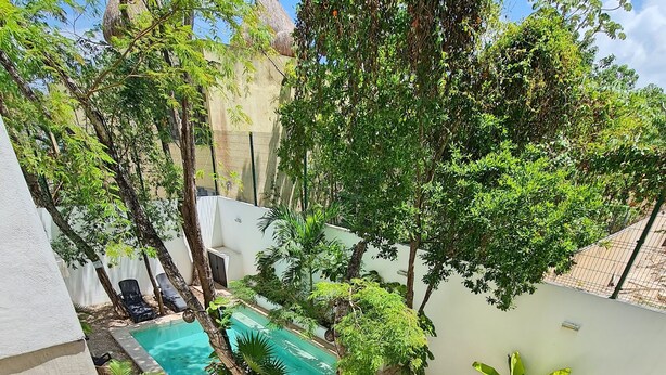 A rooftop garden with a swimming pool, lounge chairs, and potted plants. - Mi Tulum (Tulum)