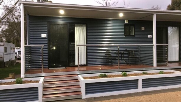 A single-story building with a covered porch, a door, and a small window. - Acacia Caravan Park (Ararat)