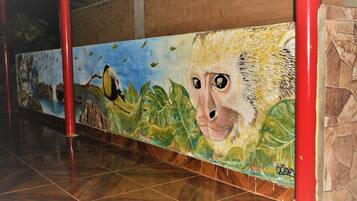 Une fresque représentant une grande tête d’animal, un oiseau et des feuillages.