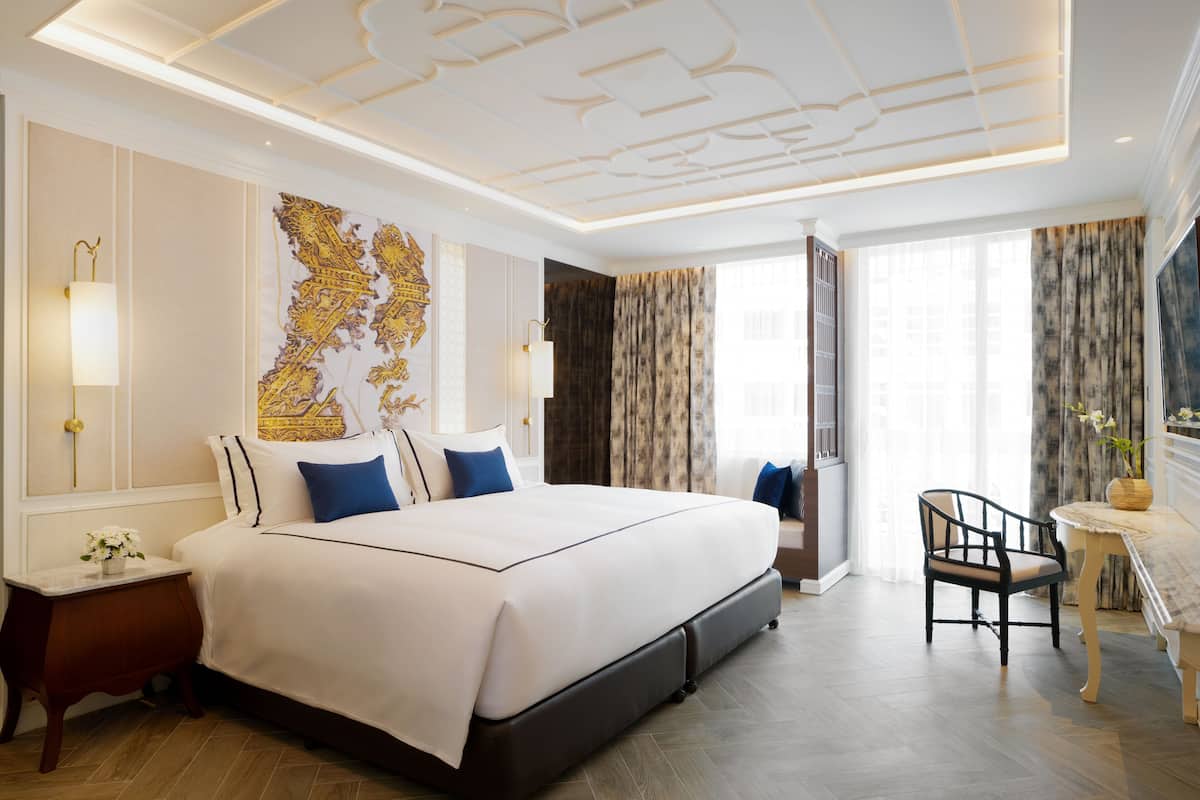 Une chambre d’hôtel avec un grand lit, un bureau et une chaise.