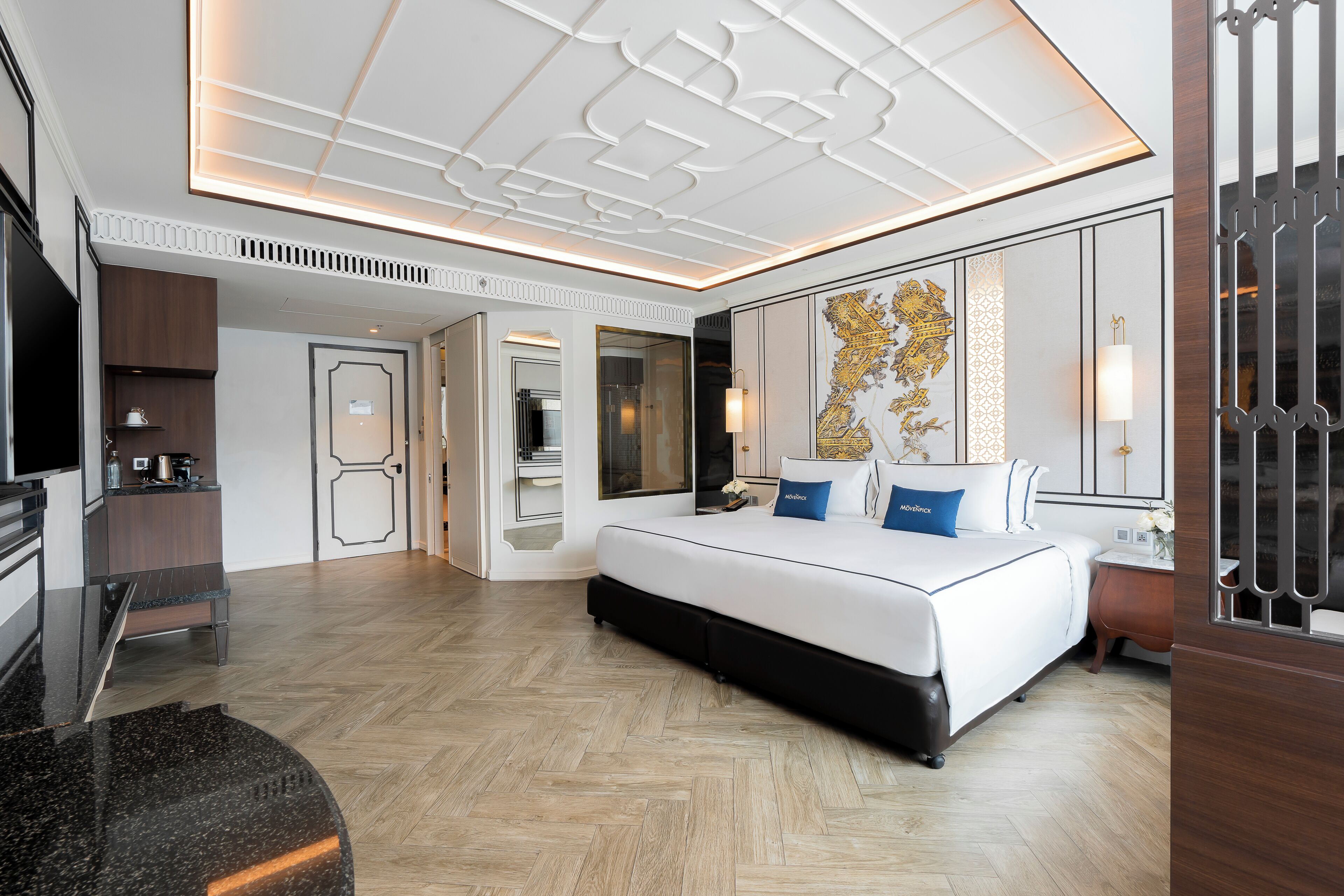 Une chambre d’hôtel moderne équipée d’un grand lit, d’un bureau et d’une télévision.