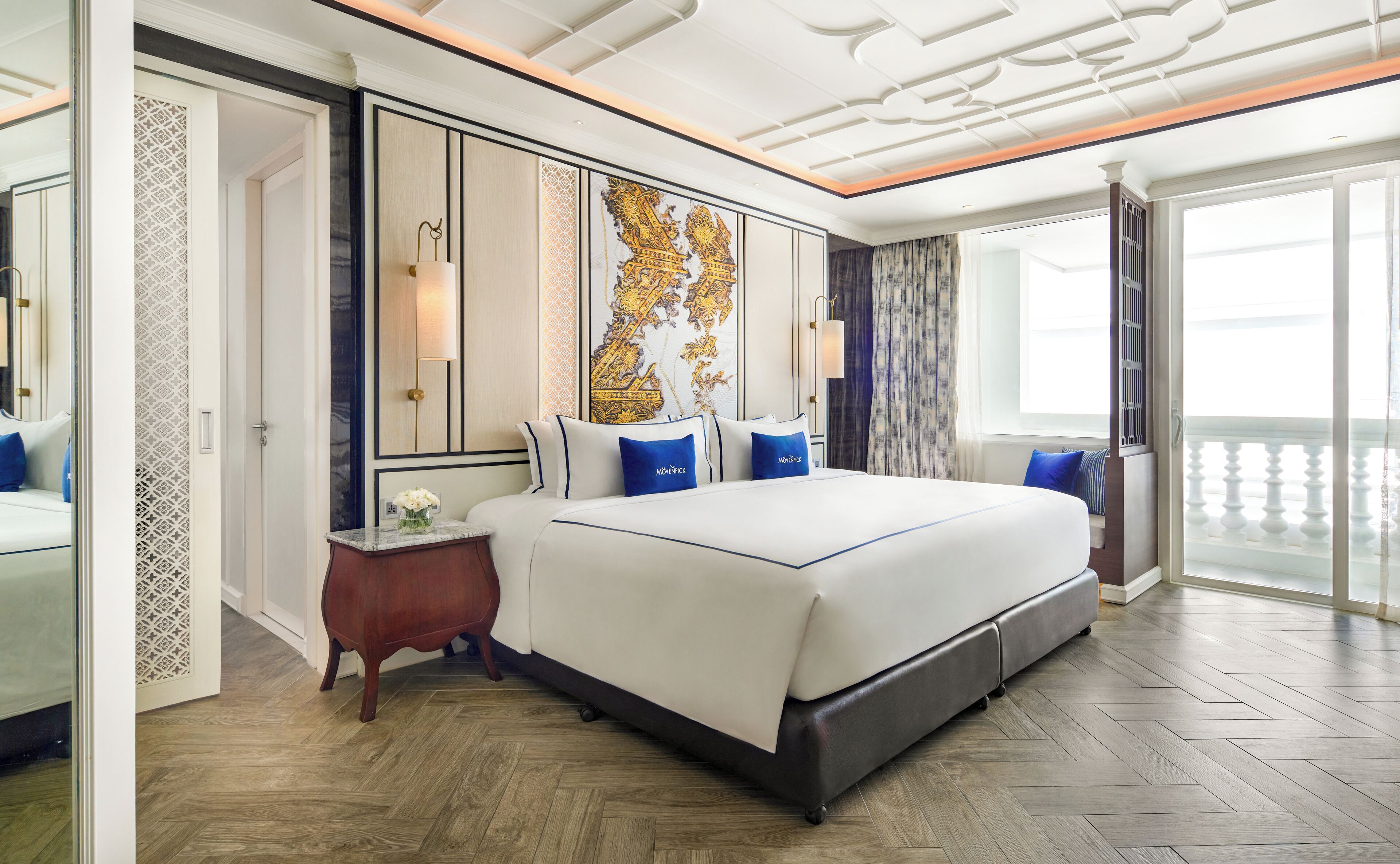 A spacious bedroom with a large bed, a nightstand, and a decorative wall piece.