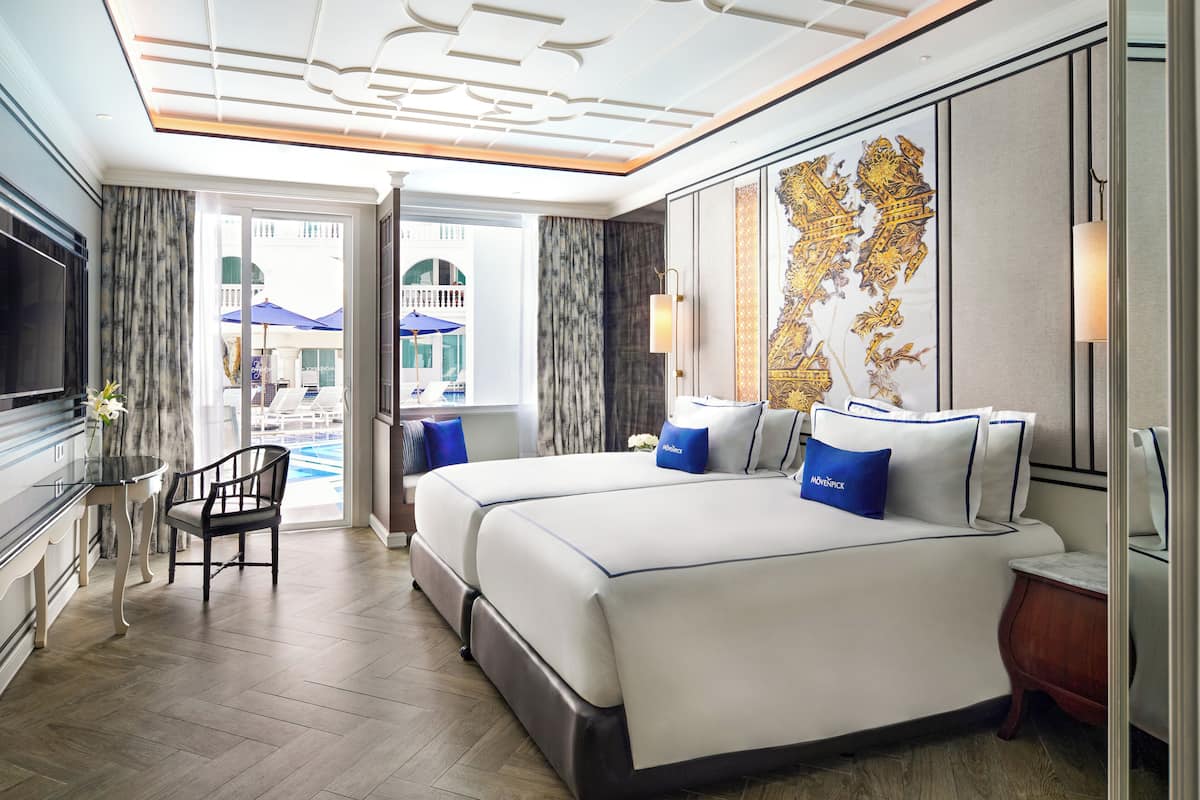Une chambre d’hôtel avec un grand lit, un bureau et une vue sur la piscine.
