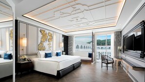 A modern hotel room with a large bed, a TV, and a view of a bridge. - Mövenpick Myth Hotel Patong Phuket (Patong)