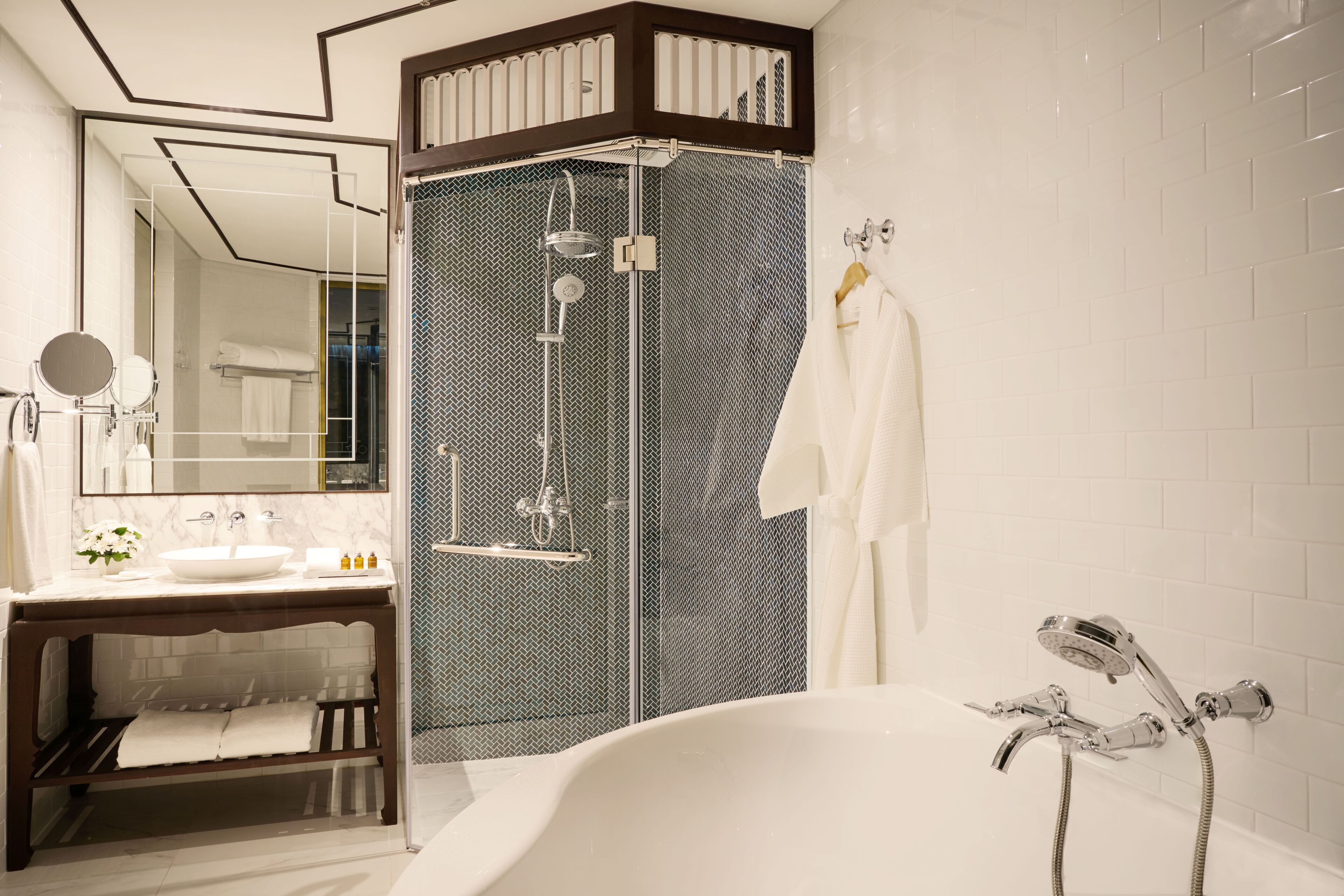 Un baño moderno con una bañera independiente, una ducha con cerramiento de vidrio y un lavabo con espejo y lavamanos.