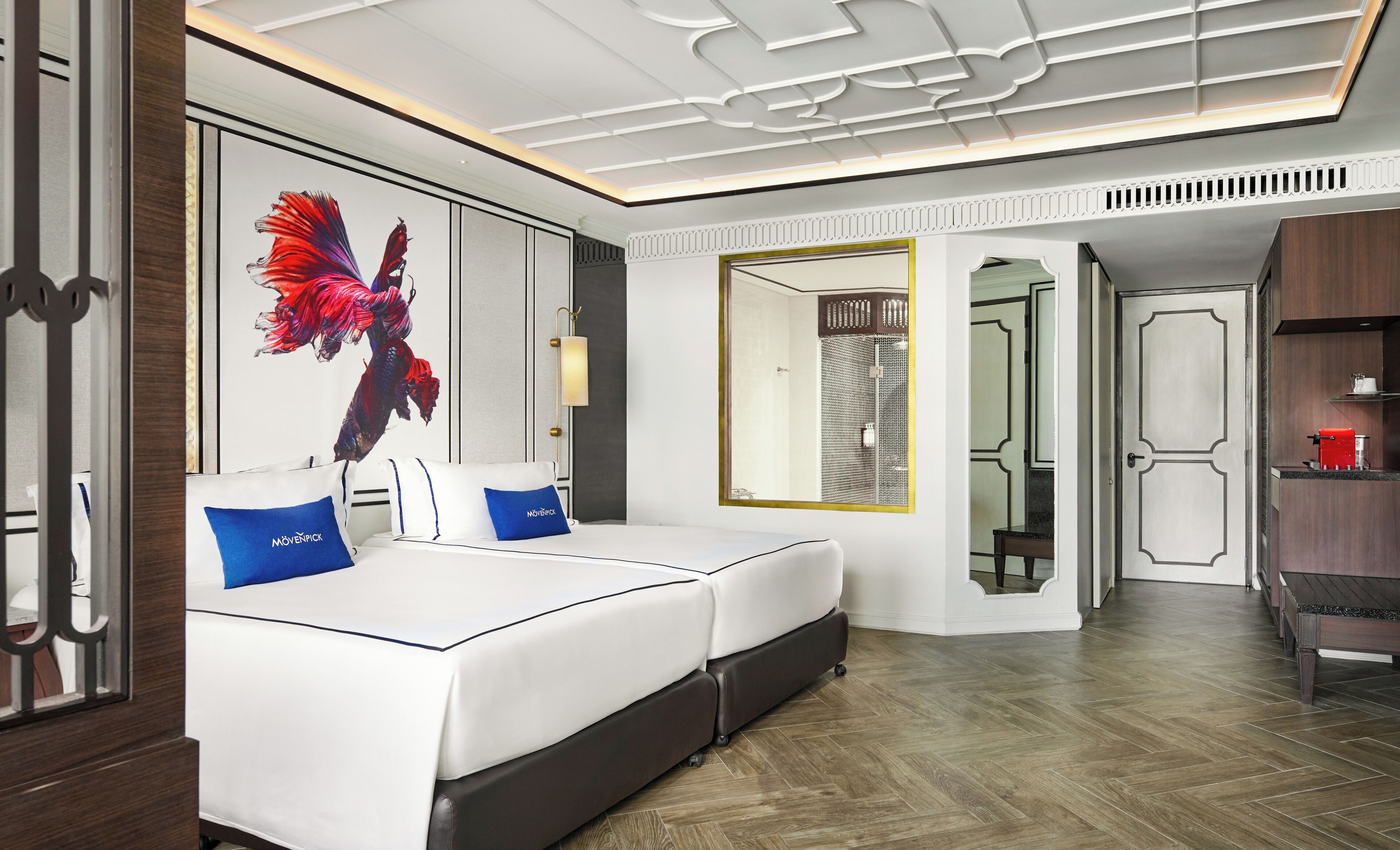 A hotel room with a large bed, a mirror, a shower, and a coffee machine.