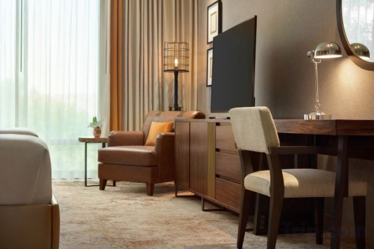 Een moderne woonkamer met een bank, fauteuils, een salontafel en een televisie.