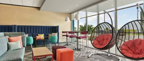 Ein stilvoller Lounge-Bereich mit einer Couch, Hocker, Sesseln und einem Tisch.