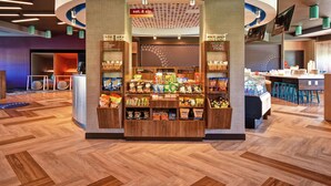 A snack kiosk with a variety of snacks and a 24/7 service sign. - Tru by Hilton Wytheville (Wytheville)
