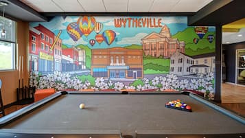 A pool table with a mural depicting Wytheville's landmarks and hot air balloons.