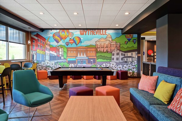 Una sala de billar con un mural de Wytheville, una mesa de billar y asientos cómodos.