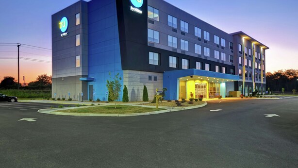 A modern hotel with a prominent 'tru' logo, a well-lit entrance, and a parking area. - Tru by Hilton Wytheville (Wytheville)