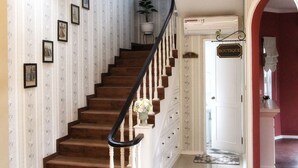 A staircase with wooden steps and white balusters, leading to a room labeled "BOUTIQUE". - Omah Madam Bed & Breakfast (Semarang)