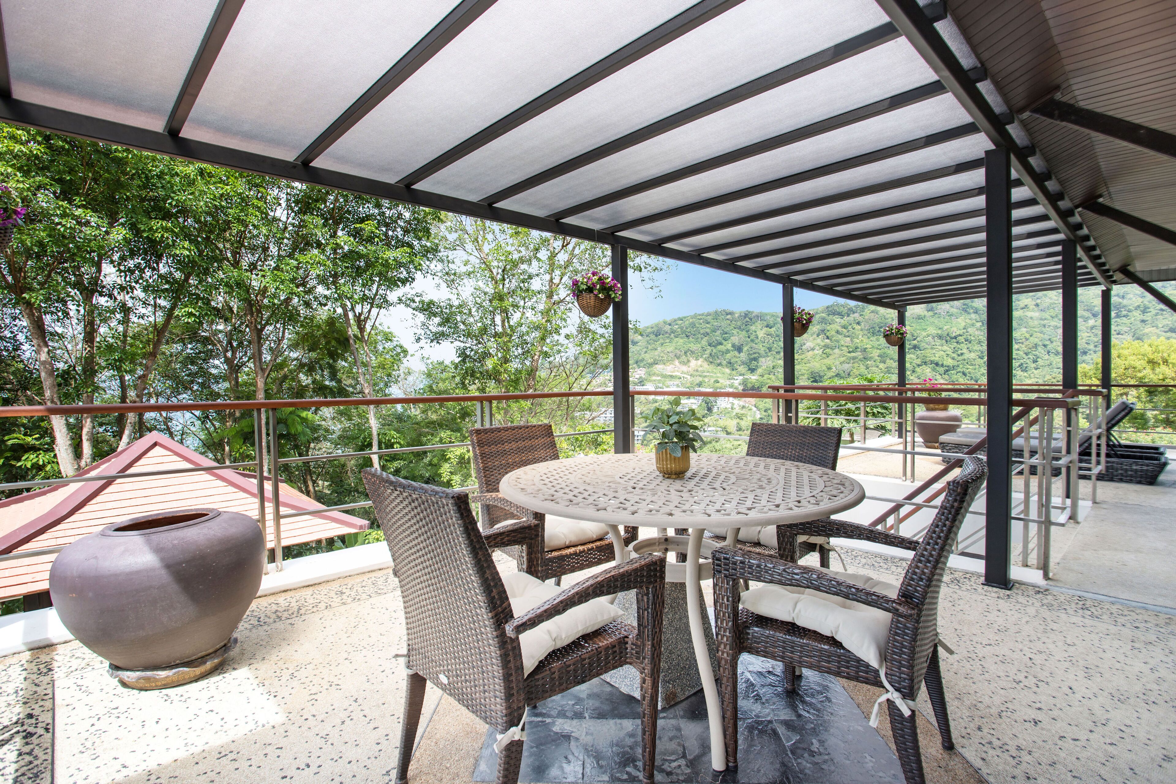 An outdoor patio with wicker furniture, a round table, and hanging planters.