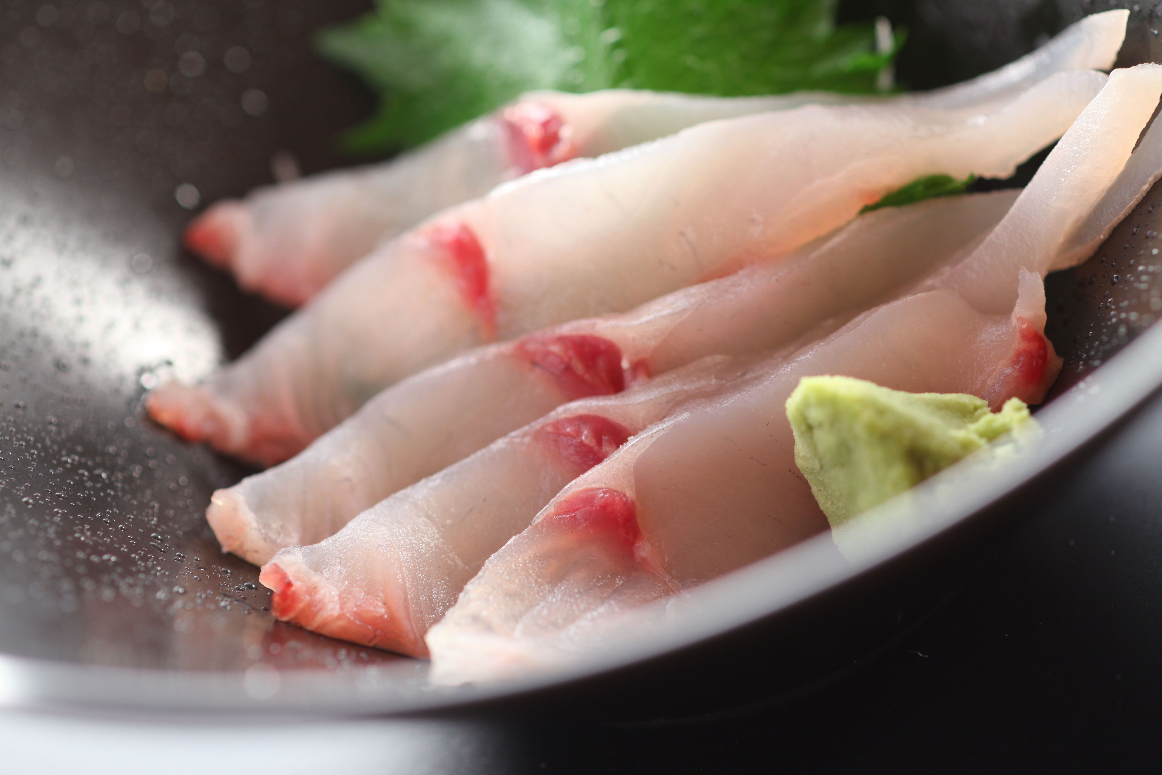 A close-up of raw fish fillets on a plate.