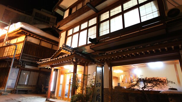 A traditional Japanese building with a wooden structure, a tiled entrance, and a sign with Japanese characters. - Hatsunoyu hotel (Yamanouchi)