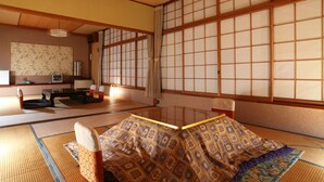 A traditional Japanese tatami room with tatami mats, a low table, and a shoji screen. - Hatsunoyu hotel (Yamanouchi)