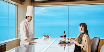 Un chef prepara comida en una mesa con vista al océano.