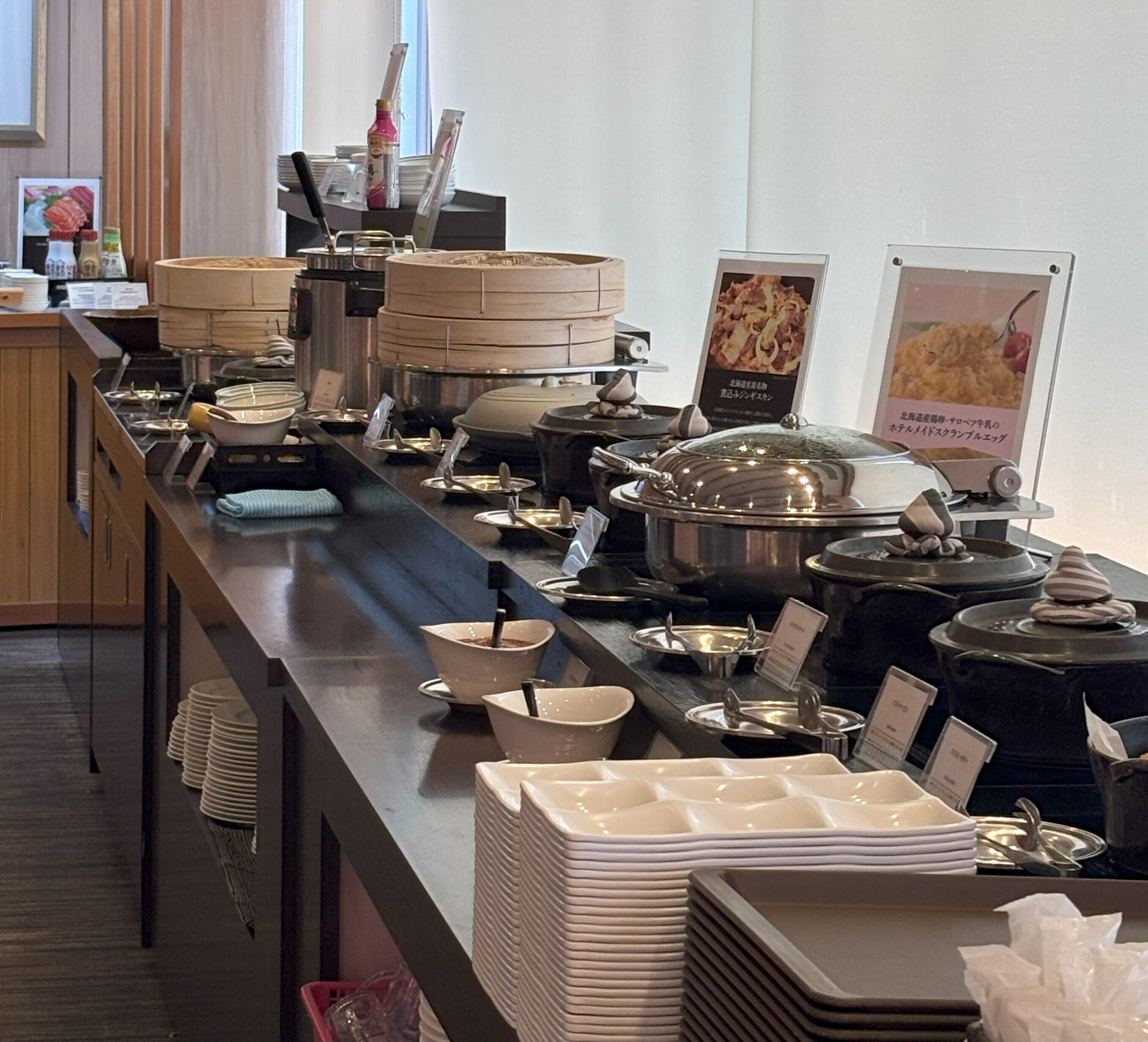 En buffet med forskellige madbeholdere og serveringsredskaber.
