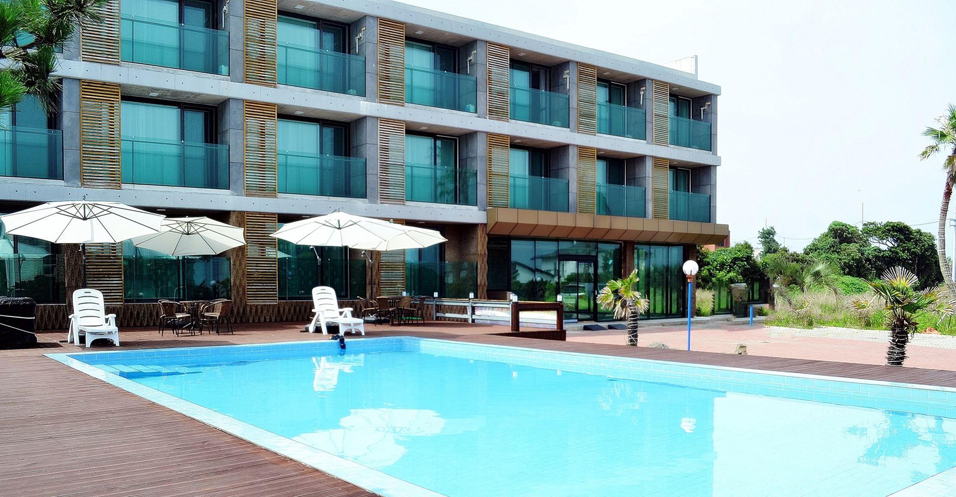 Um hotel moderno com piscina, área de estar externa e grandes janelas.