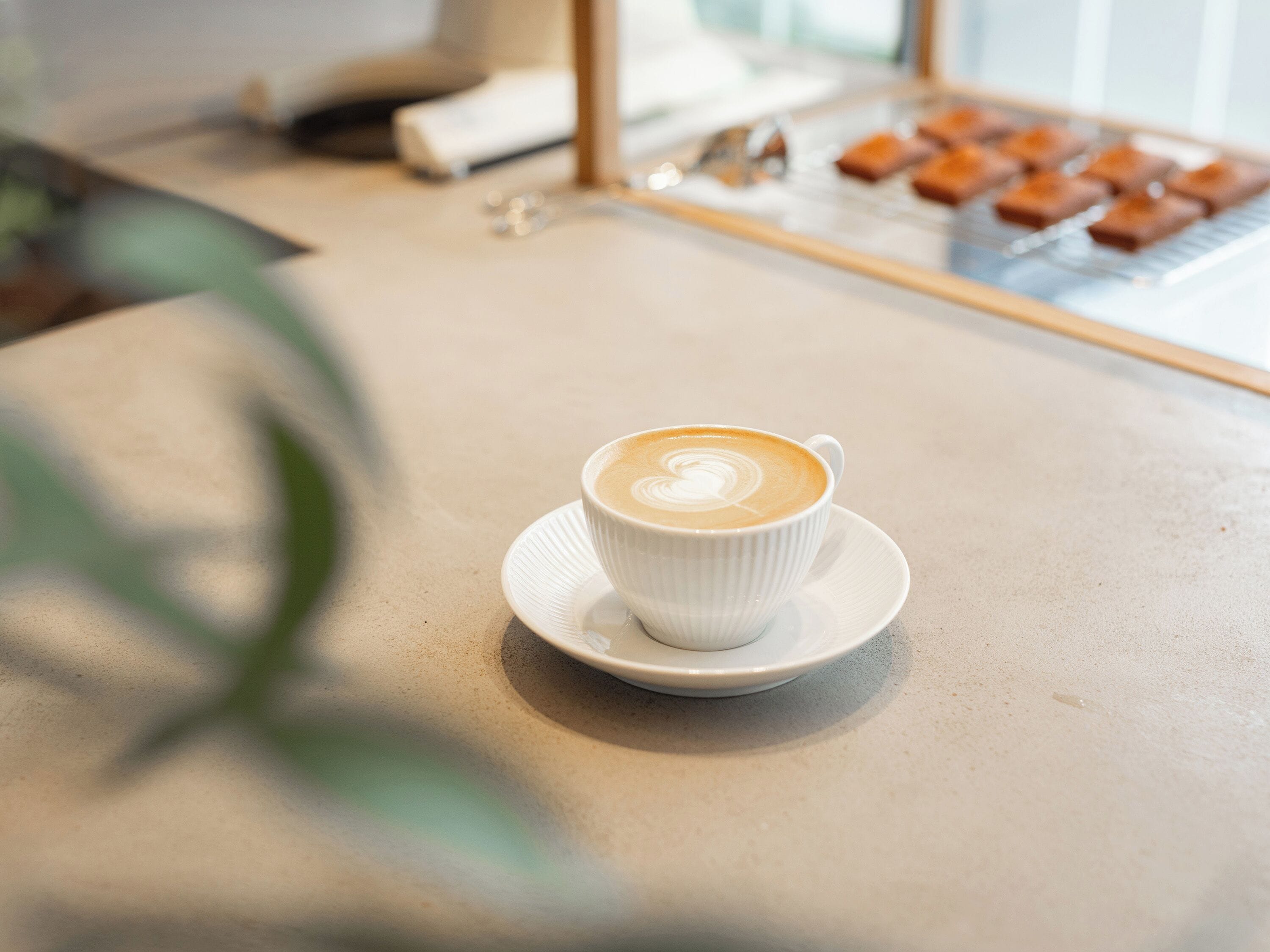 A cup of coffee on a saucer on a table.